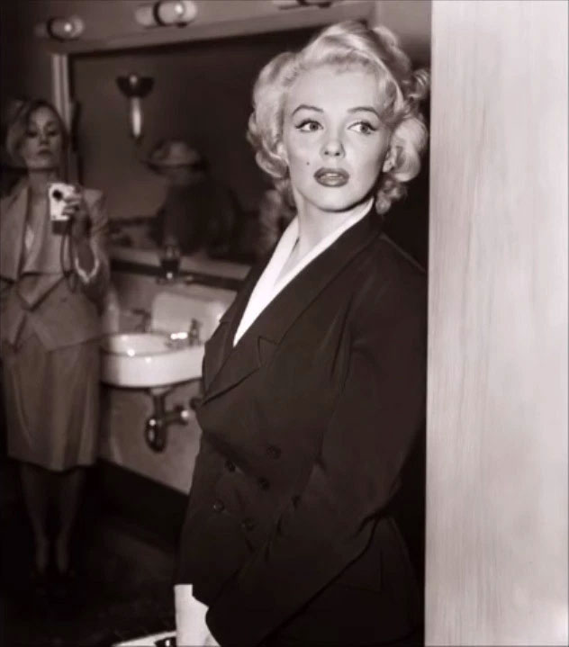 marilyn-monroe Người phụ nữ phía sau Marilyn Monroe cầm đồ vật giống máy ảnh hiện đại.